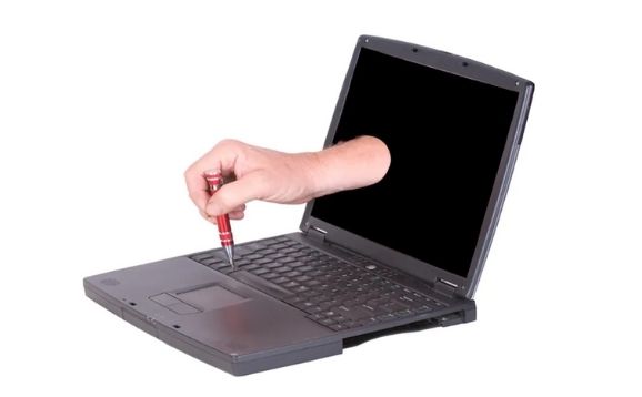 A laptop with a hand coming out of the screen and fixing the keyboard