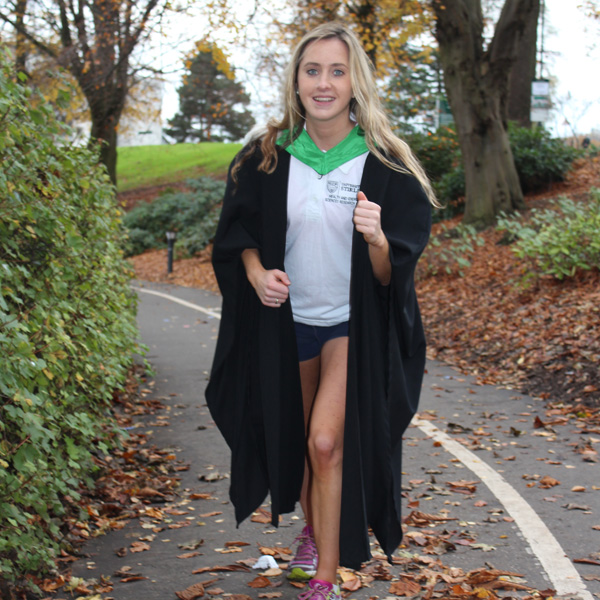 student in graduation robe and running shoes